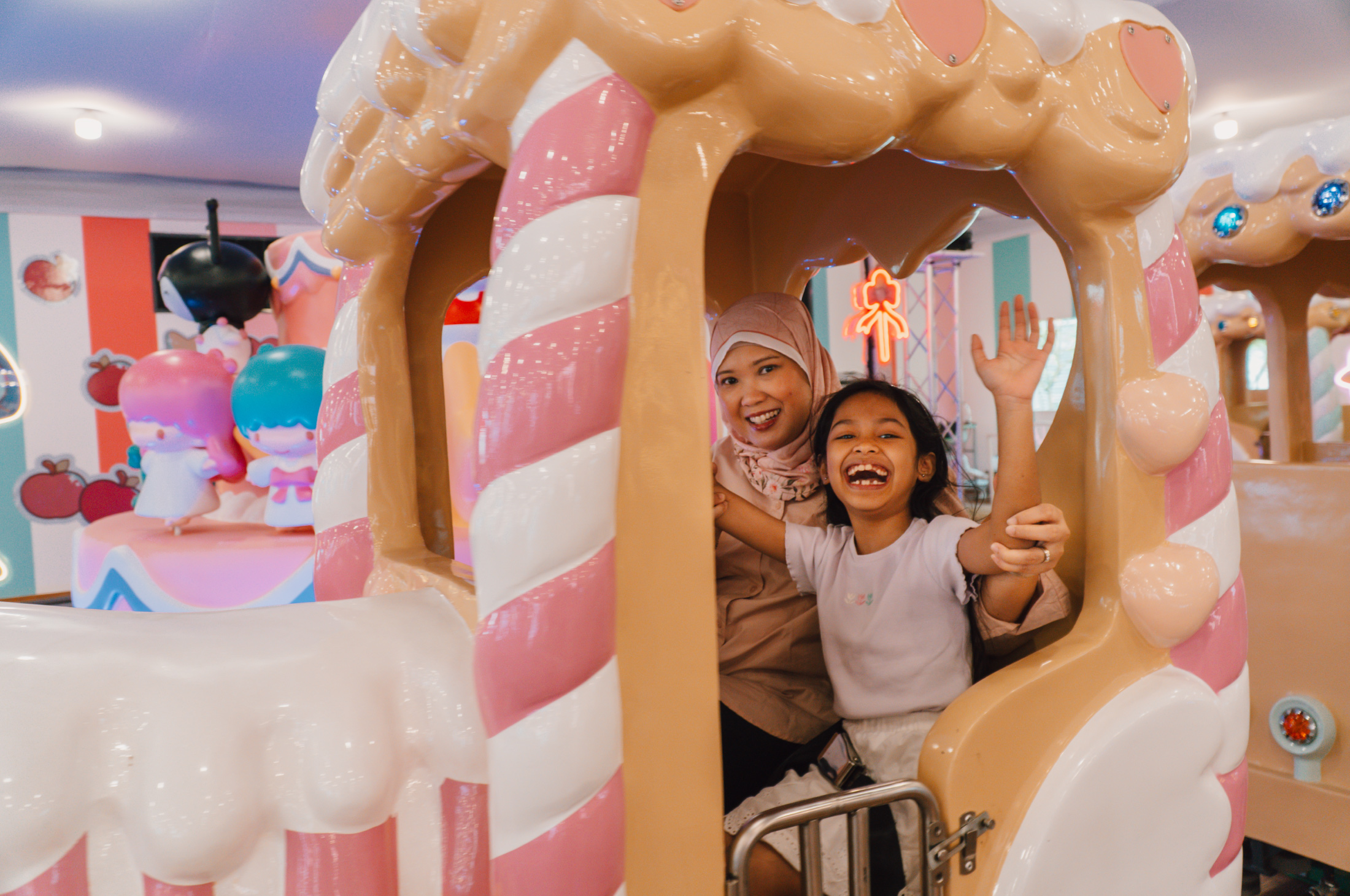 Mother and daughter laughing while on the 50th Celebration Grand Express at a carnival in Changi Airport